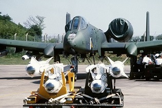 A front view of an A-10 Thunderbolt II aircraft being uploaded with AGM-65 Maverick missiles.