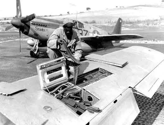 Crew dari Skuadron Tempur ke-100, Grup Tempur ke-332, A.S. ke-15. Angkatan Udara memeriksa sabuk amunisi kaliber .50 (12,7 mm) senapan mesin Browning di sayap Mustang P-51B Amerika di Italia, sekitar September 1944