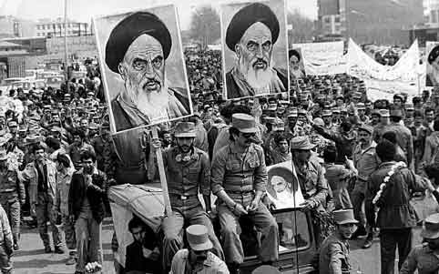 Tentara Republik Syiah Iran membawa poster Ayatollah Khomeini selama revolusi 1979.