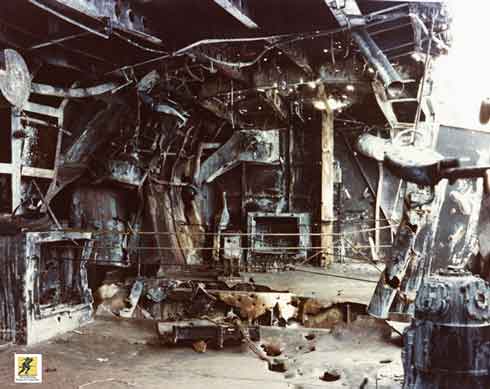 Galeri salah satu meriam kanan 5 inci Enterprise rusak berat akibat bom Jepang selama Pertempuran Solomon Timur. Enterprise selamat dari pertempuran