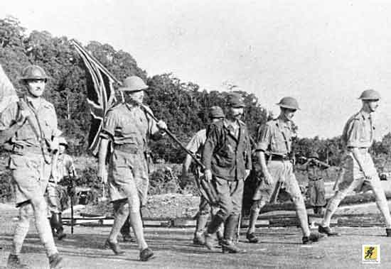 Letnan Jenderal Arthur Percival (kanan), dipimpin oleh Ichiji Sugita, berjalan di bawah bendera gencatan senjata untuk merundingkan penyerahan pasukan Persemakmuran di Singapura, 15 Februari 1942.