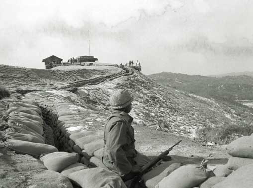 Seorang tentara yang berdiri di atas bukit yang berbatasan dengan DMZ antara Korea Utara dan Korea Selatan mengawasi aktivitas yang mencurigakan pada tahun 1968. Keamanan perbatasan sangat longgar di beberapa daerah, sehingga memungkinkan para pembunuh komunis menyelinap masuk dalam misi untuk membunuh pemimpin Korea Selatan yang sangat berkuasa, Park Chung-hee.