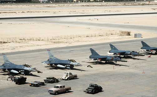 Bandara Internasional Doha: Sebuah trailer persenjataan diparkir di depan dua pesawat tempur F-16C Fighting Falcon Angkatan Udara AS dari Skuadron Tempur Taktis ke-614, Sayap Tempur Taktis ke-401, Pangkalan Udara Torrejon, Spanyol. Pesawat F-16C dipersenjatai dengan bom dan rudal udara-ke-udara AIM-9 Sidewinder yang dipersiapkan untuk misi selama Operasi Badai Gurun. Di sebelah kanan adalah tiga pesawat tempur F-1C Mirage Prancis dari 12e Escadre de Chasse yang dipersenjatai dengan rudal Matra R550 Magic II.