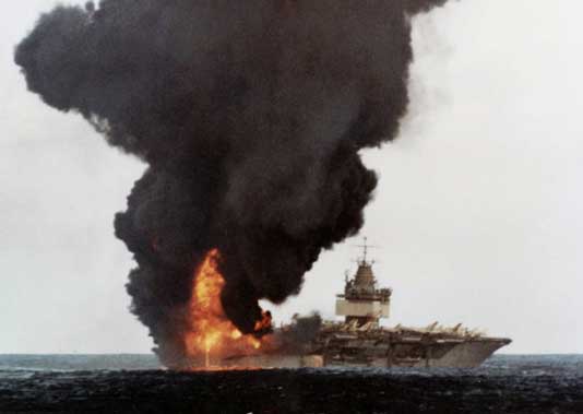 Asap hitam mengepul dari USS Enterprise (CVAN-65) setelah kebakaran yang terjadi ketika ia sedang melakukan operasi udara dekat Hawaii pada 14 Januari 1969. Kebakaran besar dimulai ketika sebuah roket Zuni secara tidak sengaja meledak di bawah sayap F-4 Phantom II.