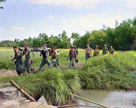 Anggota Brigade Marinir Belanda membawa rekannya yang terluka di dekat Gedangan (selatan Surabaya, Jawa Timur), Juni 1946, Hindia Belanda (sekarang Indonesia).